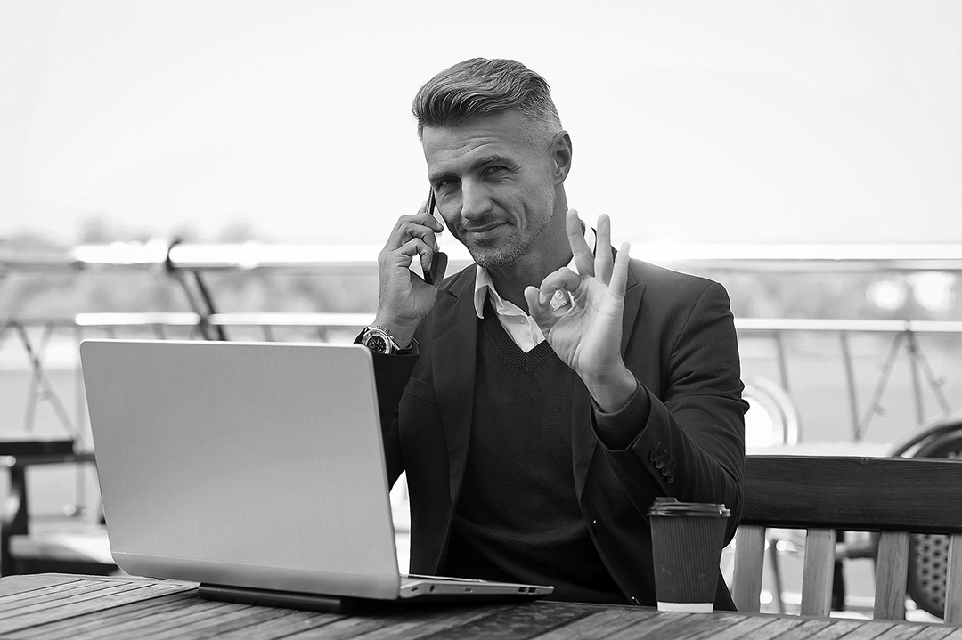 Now thats what I call OK. Handsome man show OK talking on phone. Agreement and permission. Project manager work in cyber cafe. Modern lifestyle. Business communication